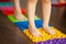 Children walking on a orthopedic massage mat. Treatment and prevention of flat feet in children