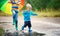 Children walking in wellies in puddle on rainy weather