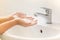 Children washing hand with foam soap in bathroom sink