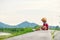 A children wear hat and sitting on the gound and flower near him.