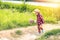 A children wear hat and walking on stair. A children hold flower and near the road.