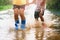 children wearing rain boots and jumping in puddle on rainy