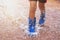 children wearing rain boots and jumping in puddle on rainy