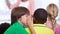 Children, whisper and classroom in ear for secret, gossip or communication in lesson at school. Person, students or