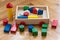 Children wooden trolley with colorful wooden cubes, cylinders an