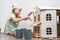 Children at work: The girl neatly paints the facade of the doll house with a small tassel in white.