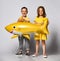 Children in yellow clothes, wears a balloon in the shape of a yellow shark fish, celebrates a holiday, has a wide smile, stands on