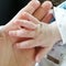 Childrens palm in the palm of an elderly person. Link between generations. The handle of a newborn baby lies in the hand of an