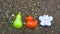 childrens toys in the sandbox on the squeak. green pear, red duck, blue butterfly