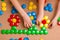 Childrenâ€™s hands put the details of colored mosaics into a drawing of flowers on the table. Leisure of the child in confinement