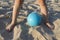 A childs feet and ball in the sand, close-up.  Beach sports