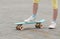 The childs feet on the sports board with wheels, skate on the asphalt