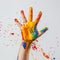 Childs hand with paint, playful angle, bright splashes , professional color grading