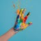 Childs hand with paint, playful angle, bright splashes , professional color grading