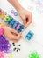 Childs hands with loom and multicoloured elastic bands