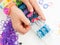 Childs hands making a multicoloured elastic band bracelet on a b