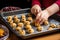 a childs hands placing cookie dough balls on a baking tray