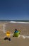 Childs sand bucket and toys on scenic sunny beach