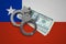 Chile flag with handcuffs and a bundle of dollars. Currency corruption in the country. Financial crimes