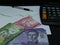 chilean banknotes, pen and calculator on background with rising trend green line