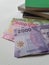 Chilean banknotes and stacked books on white background