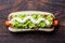 Chilean Completo Italiano. Hot dog sandwiches with tomato, avocado and mayonnaise on wooden board. Top view, copy space