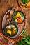 Chilean meat soup with pampkin, corn, fresh coriander and potatoes on old wooden table background. Cazuela. Latinamerican food