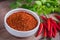 Chili cayenne in bowl and fresh chili on wooden table