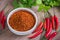 Chili cayenne in bowl and fresh chili on wooden table