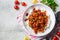 Chili con carne with rice in white bowl, top view. Beef stew with beans in tomato sauce and rice. Traditional Mexican food concept