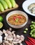 Chili paste thai language Nam prik kapi in a white bowl with ingredients and Fried steam mackerel on the table