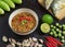 Chili paste thai language Nam prik kapi in a white bowl with ingredients and Fried steam mackerel on the table