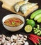 Chili paste thai language Nam prik kapi in a white bowl with ingredients and Fried steam mackerel on the table