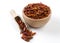 Chili peperoncini paprika pepper in wooden bowl and scoop isolated on white background. Spices and food ingredients