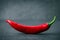 Chili pepper on black stone background , smiling shape