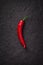 Chili pepper on black stone background , smiling shape