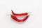 Chili pepper smile. Two whole red chili peppers on white wooden background. Flat lay, top view