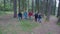 Chill group of young tourists friends trekking a mountain trail walking through forest -