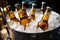 Chilled beer bottles rest in an ice filled pail, promising cold and delightful sips