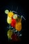 chilled fruity cocktails on a black mirrored background with slices fruits