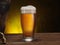 Chilled glass of beer on the wooden table. Close-up. Craft brewery