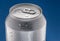 Chilled silver beer can covered with condensation on blue background