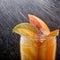 Chilled soft drinks with ice, citrus fruits and berries, black background, selective focus drop