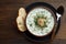 Chilled tarator with bread and spoon on wooden table ready to eat.