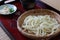 Chilled udon noodles on a bamboo colander on a tray.