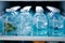 Chilled water bottles, neatly arranged, inside the cool confines of the refrigerator