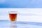 Chilled whiskey in a glass stands on ice against the background of blurry snow and sky.