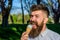 Chilling concept. Man with long beard licks ice cream, close up. Bearded man with ice cream cone. Man with beard and