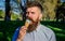 Chilling concept. Man with long beard licks ice cream, close up. Man with beard and mustache on calm face eats ice cream