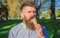 Chilling concept. Man with long beard licks ice cream, close up. Man with beard and mustache on calm face eats ice cream